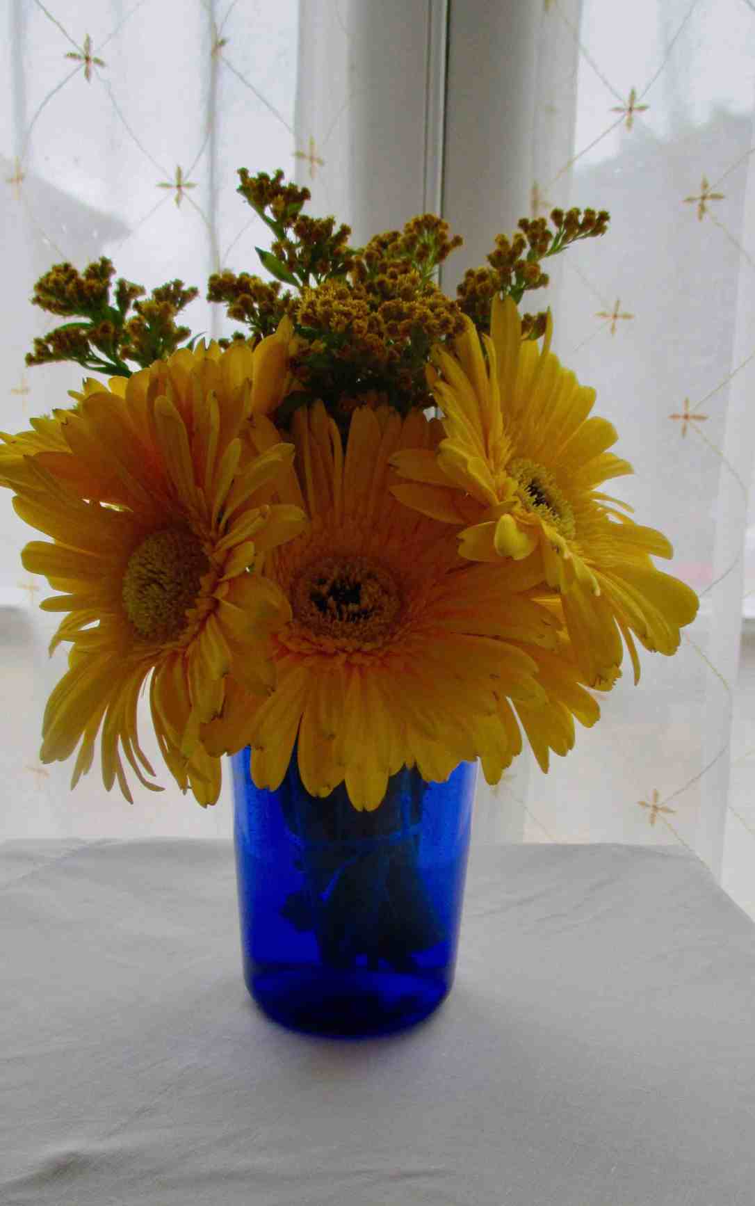 yellow gerberas in blue vase